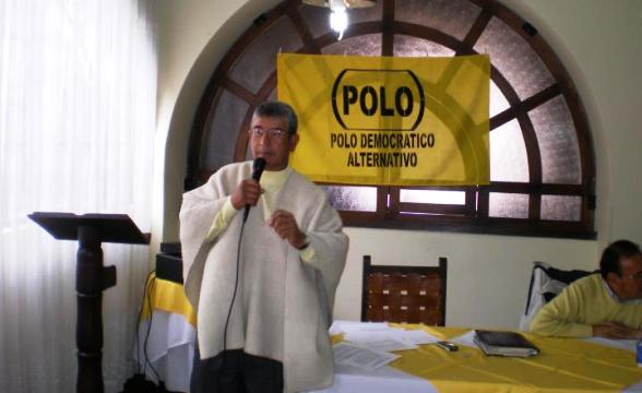 El sacerdote Gustavo Suárez Niño ofreciendo una misa en Chiquinquirá, con las banderas del comunista Polo Democrático detrás