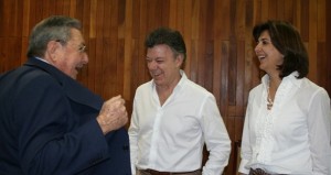 Juan Manuel Santos y la canciller maría Ángela Holguín ríen a carcajadas por lo que les enseña Raúl Castro